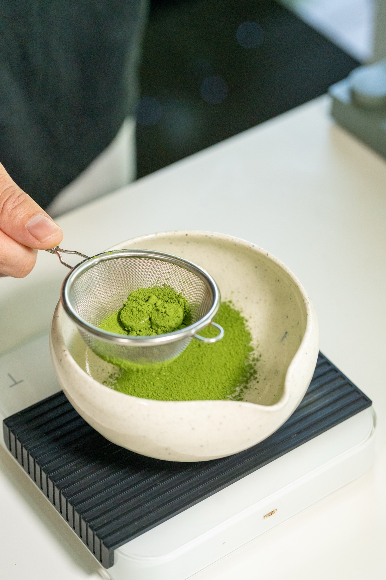 Sifting matcha powder into a bowl